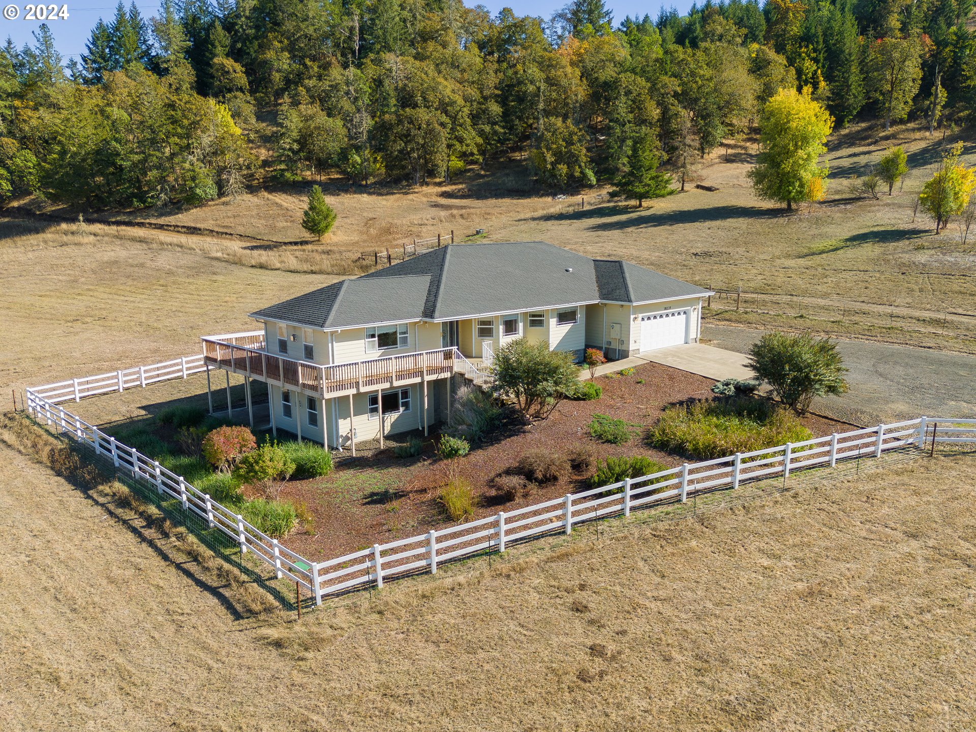 an aerial view of a house with swimming pool and large trees