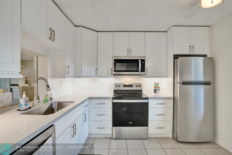 a kitchen with cabinets stainless steel appliances and a counter space