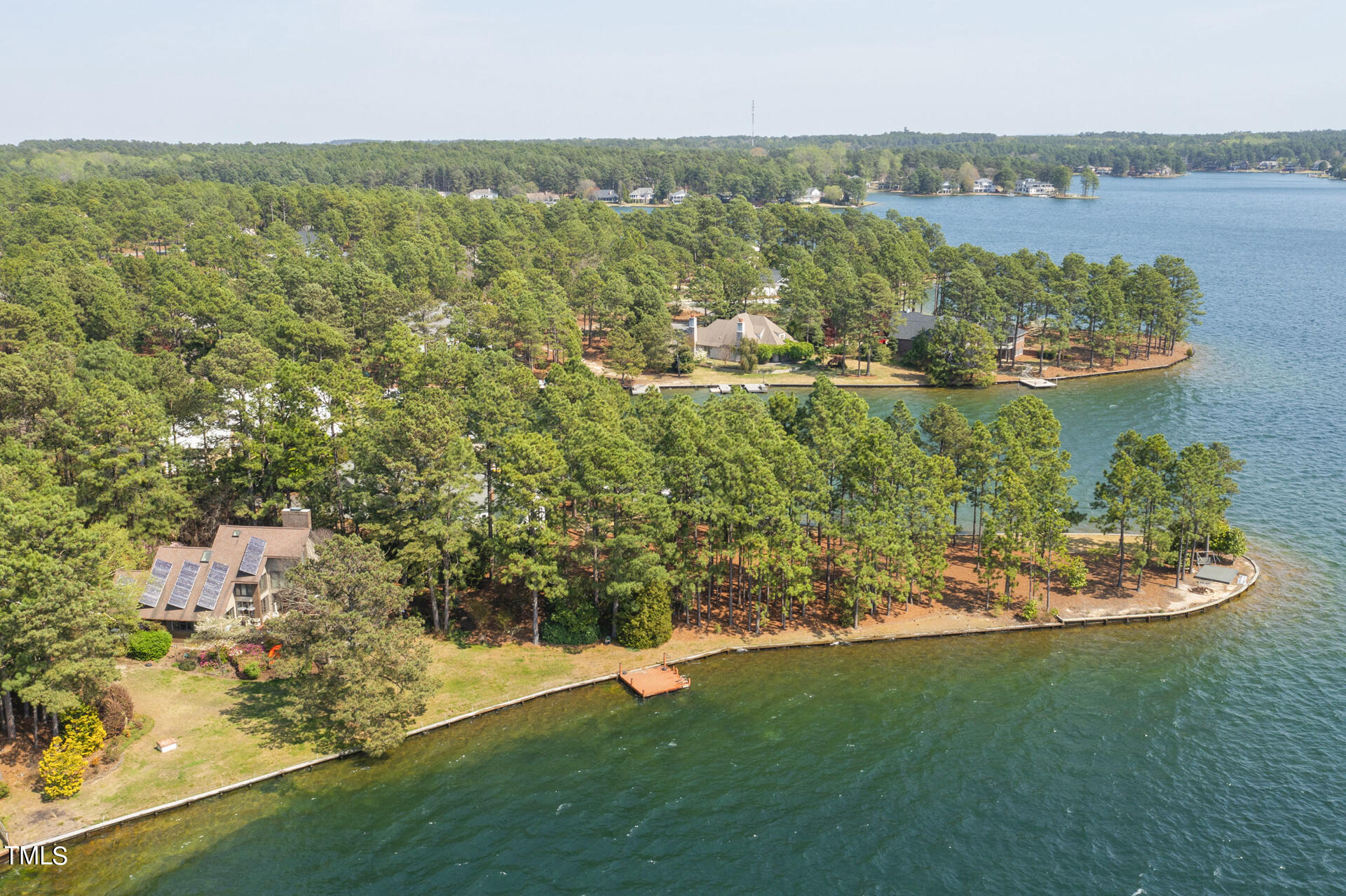 an aerial view of residential houses with outdoor space and lake view