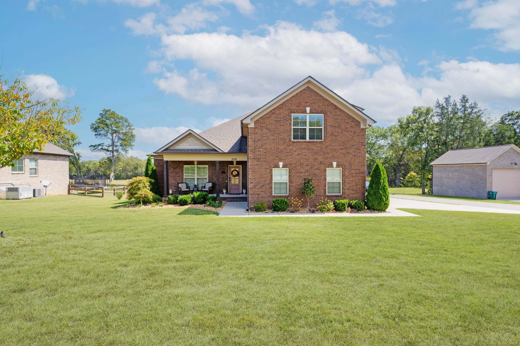 a front view of house with yard and trees in the background