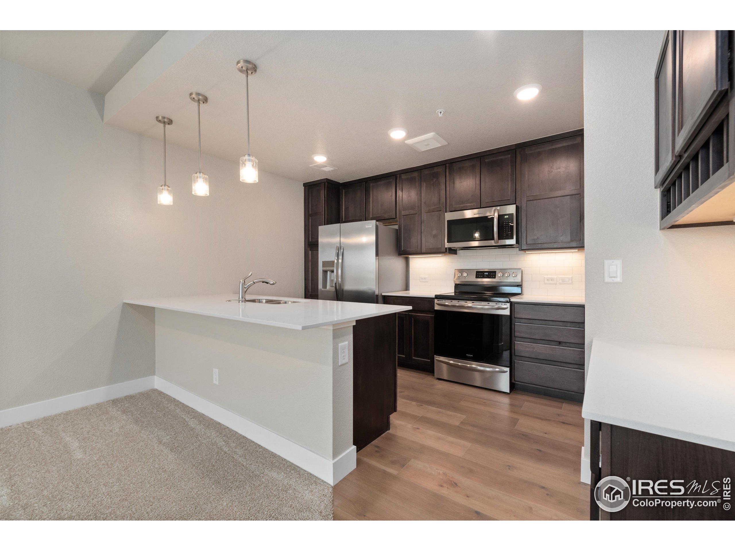 a kitchen with kitchen island a sink stainless steel appliances and cabinets