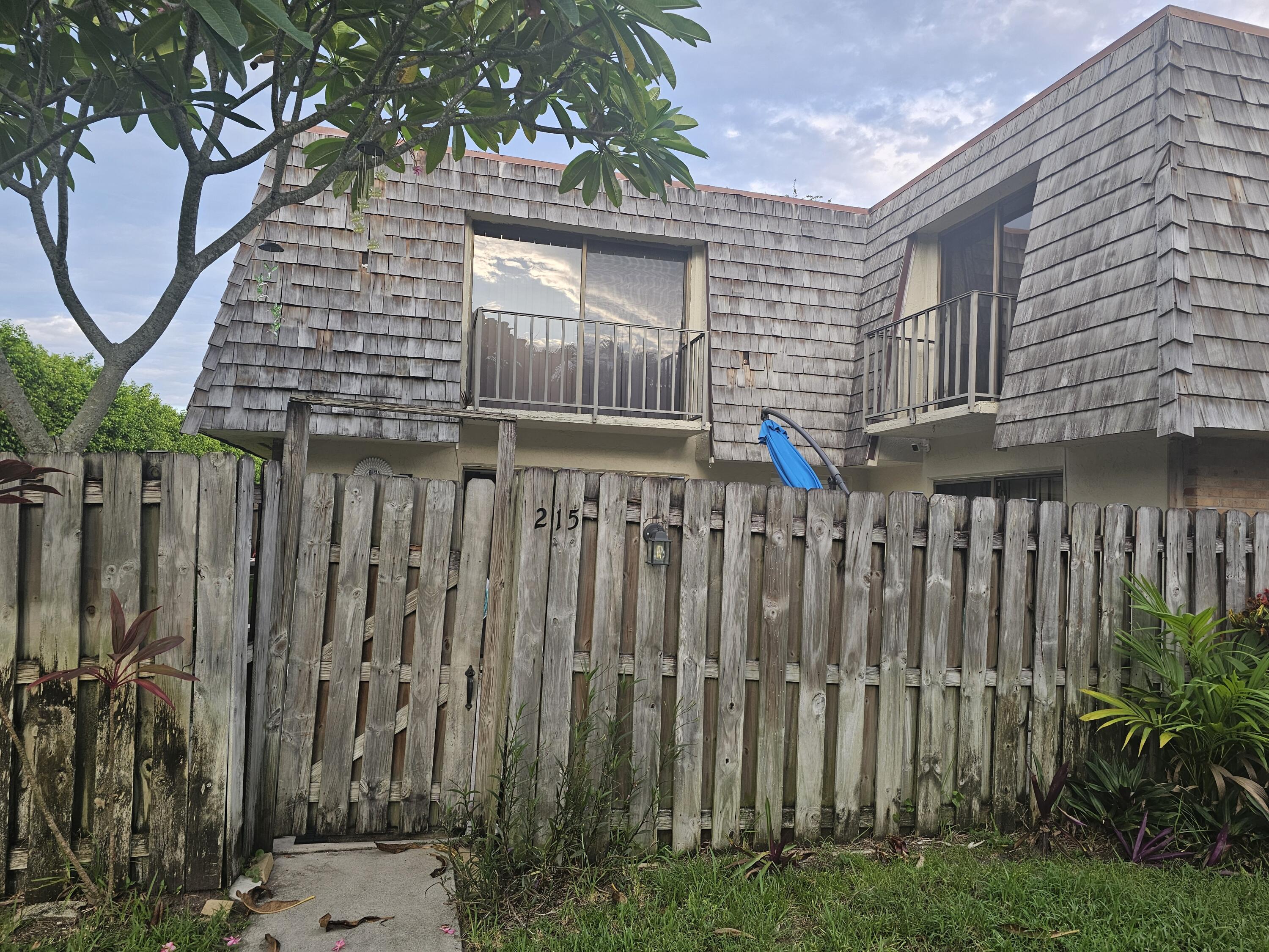 a view of a house with a wooden fence