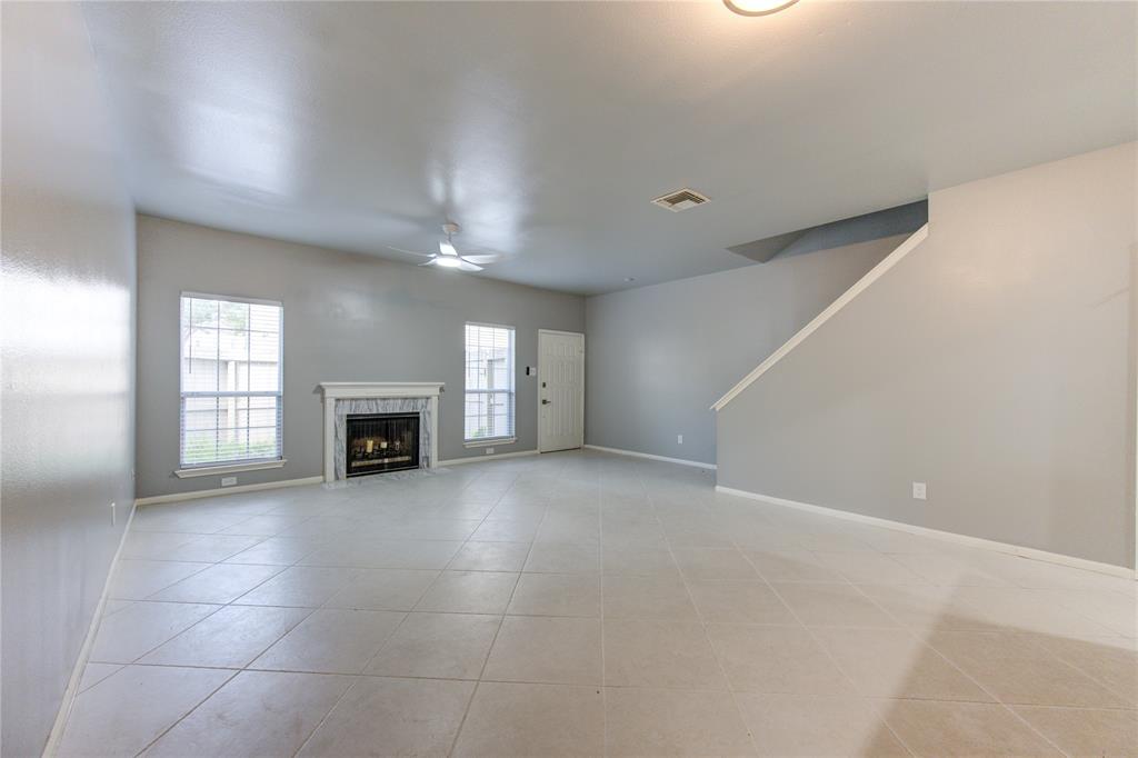 a view of an empty room with a fireplace and a window