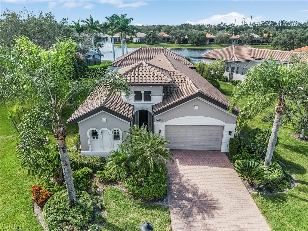 an aerial view of a house with a yard and large trees