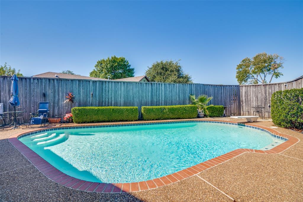 a view of a backyard with potted plants and wooden fence