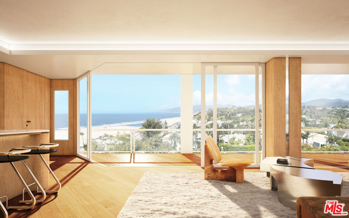 a spacious bedroom with a large window and a table chair