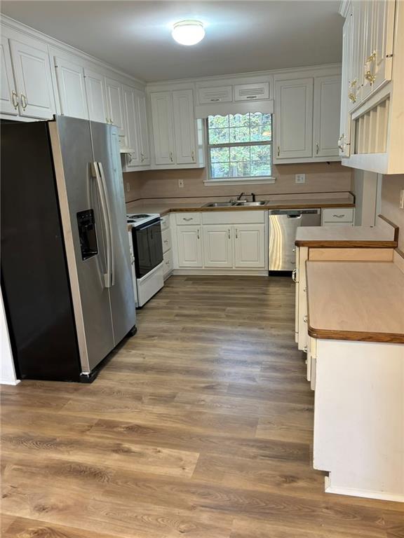 a kitchen with stainless steel appliances a refrigerator sink and cabinets