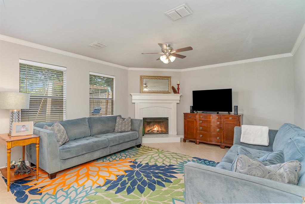 a living room with furniture a flat screen tv and a fireplace