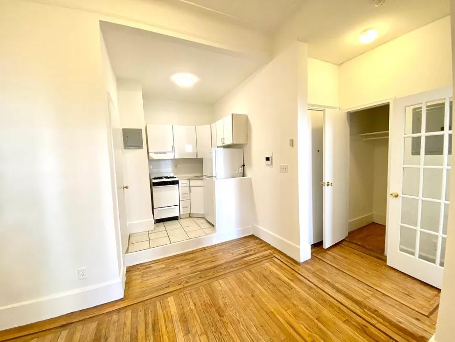 a view of a kitchen with wooden floor and a kitchen