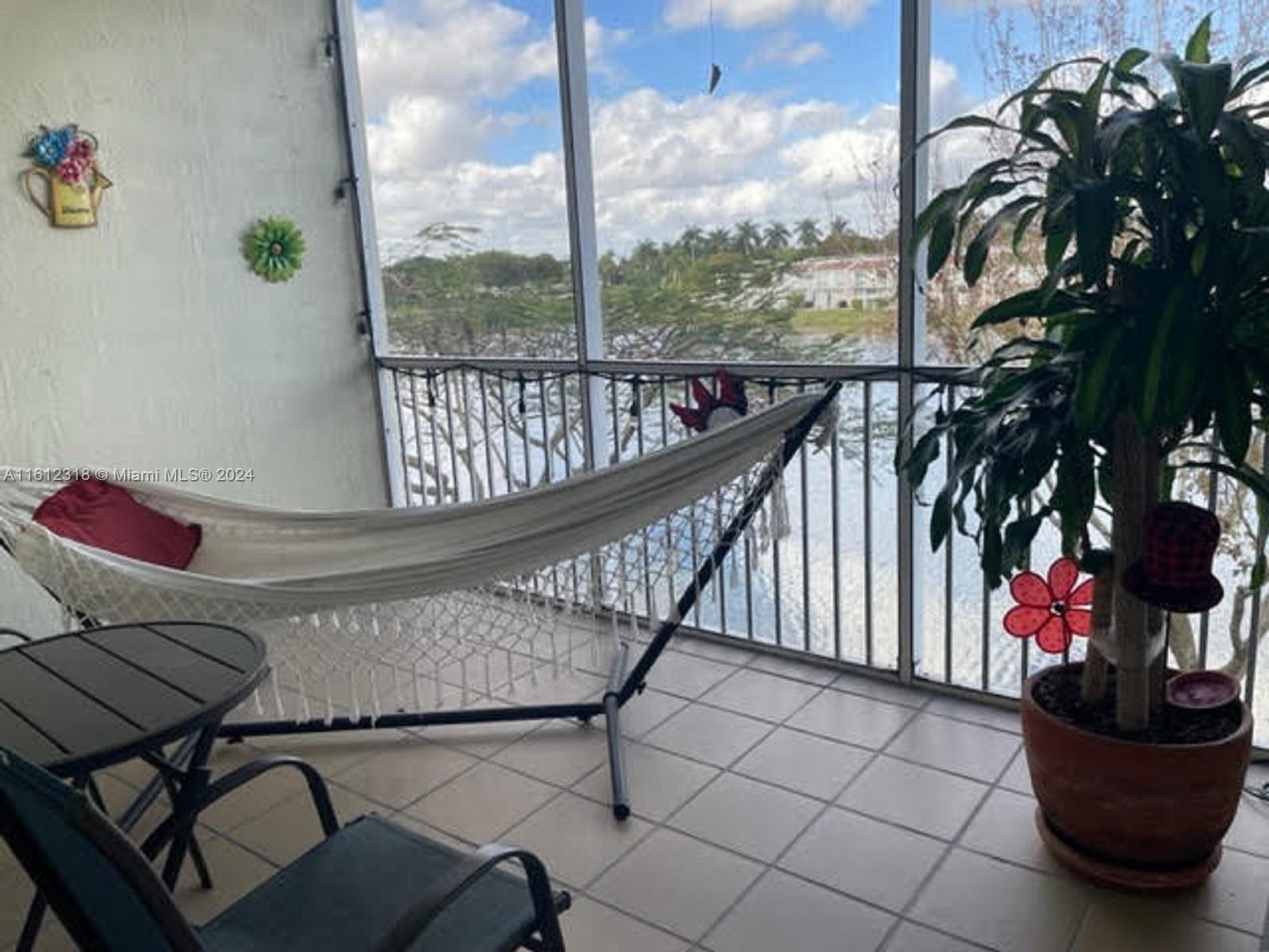 a view of a balcony with chairs and potted plants