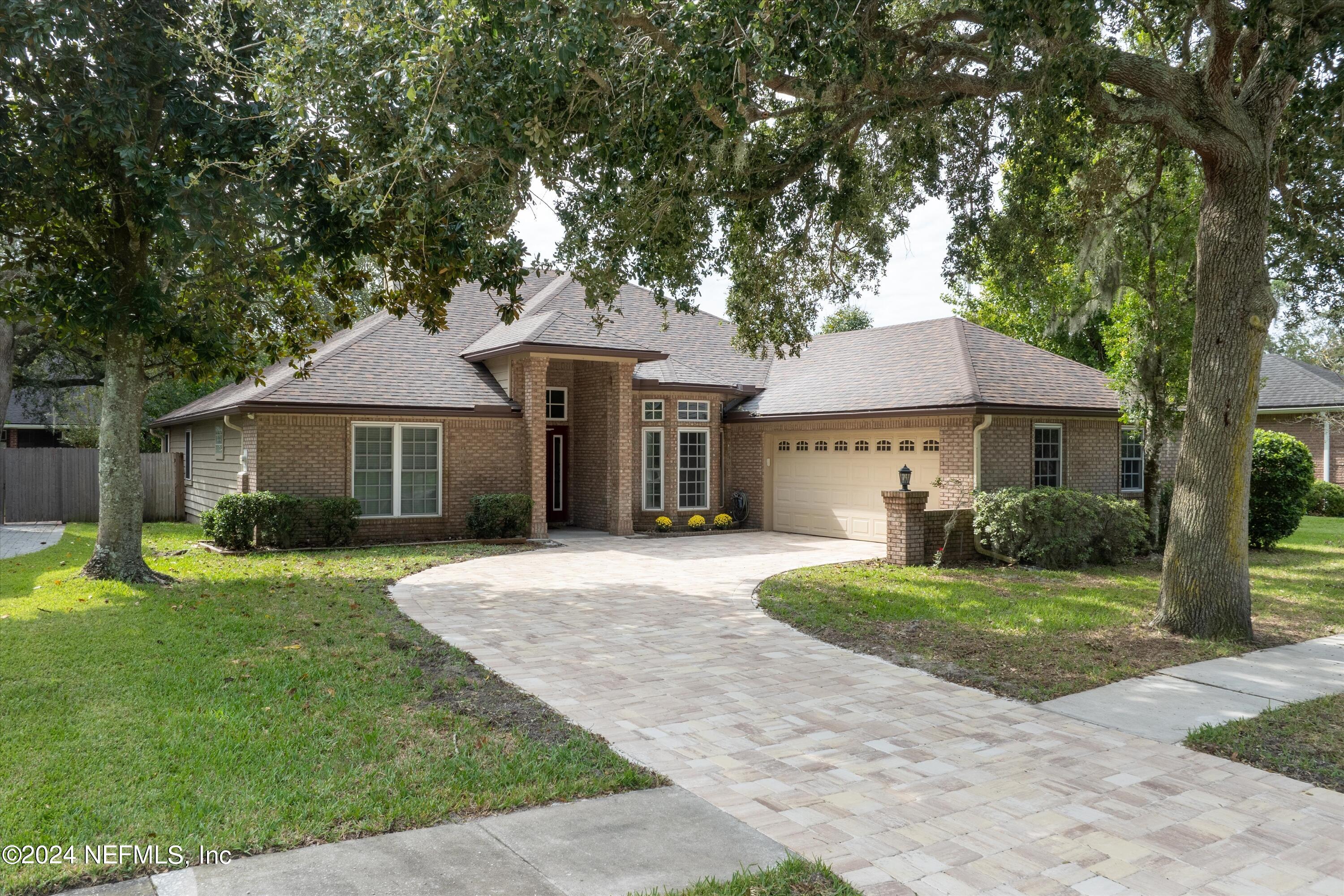 a front view of a house with a yard and trees