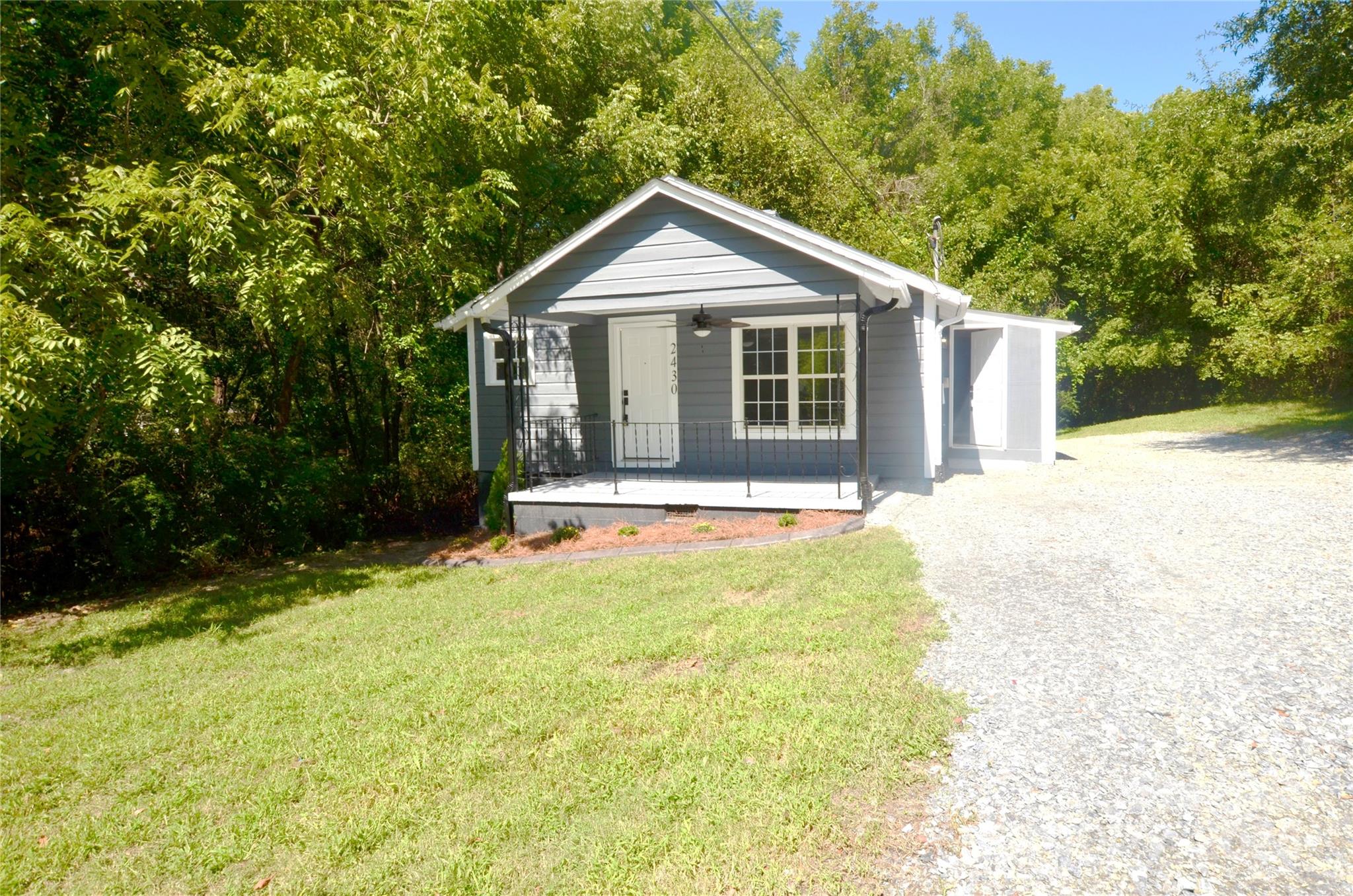 a view of a house with backyard and trees