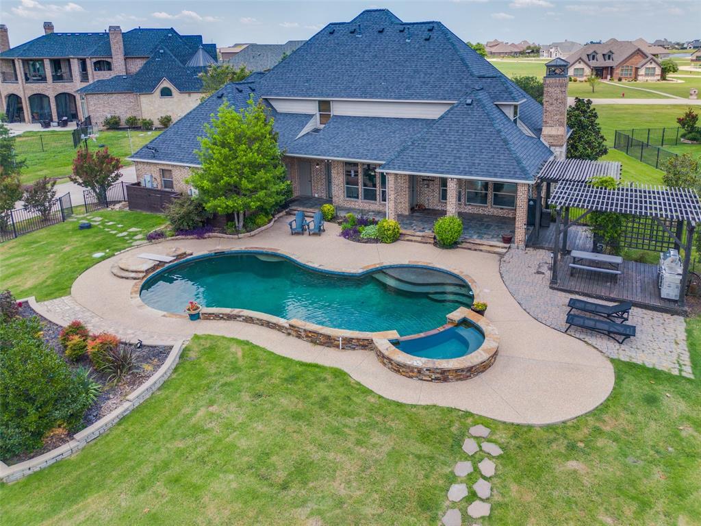 a aerial view of a house with swimming pool and a yard