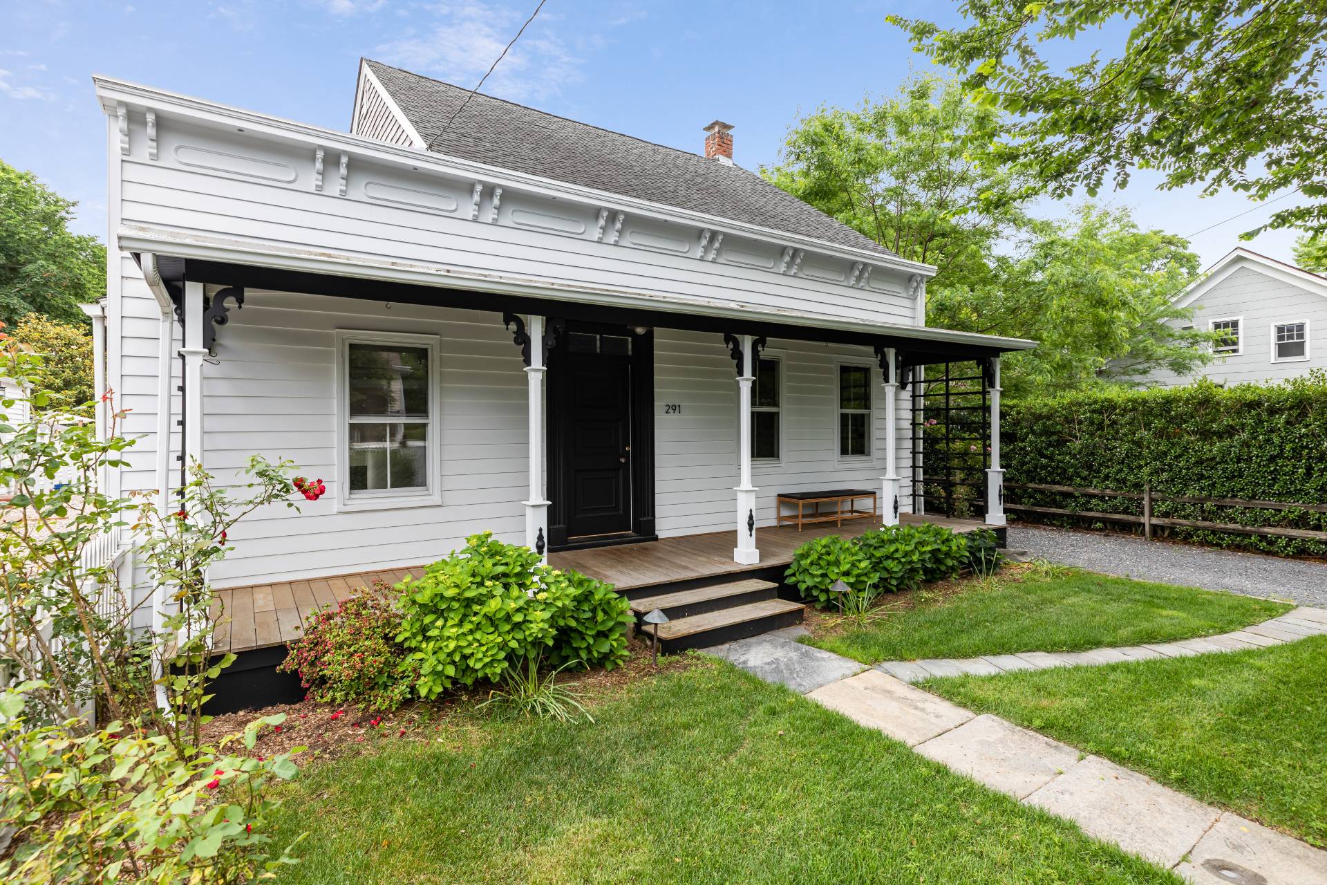 a view of a house with potted plants and a large tree