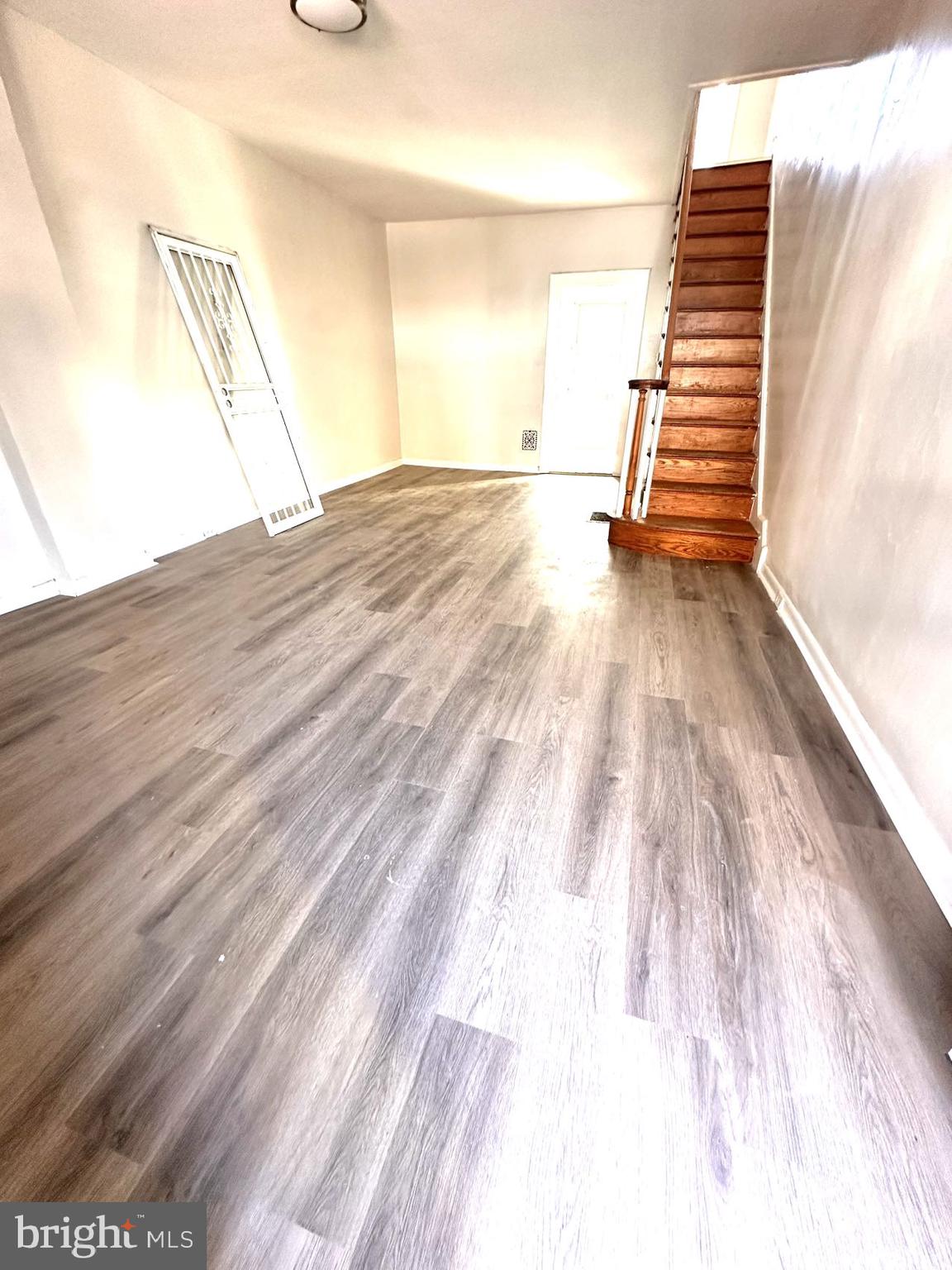 a view of a hallway with stairs and wooden floor