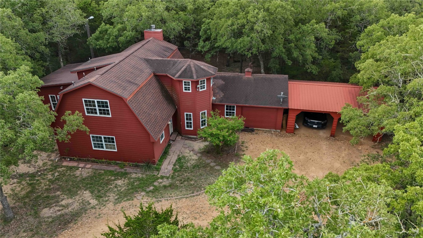 an aerial view of a house with a yard and large tree