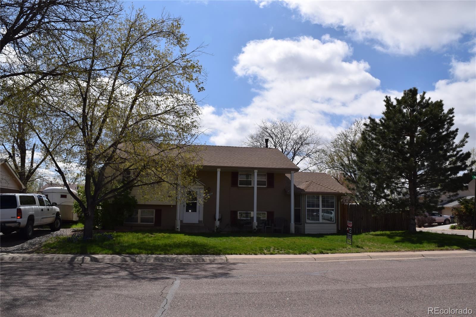 a front view of a house with a yard and trees