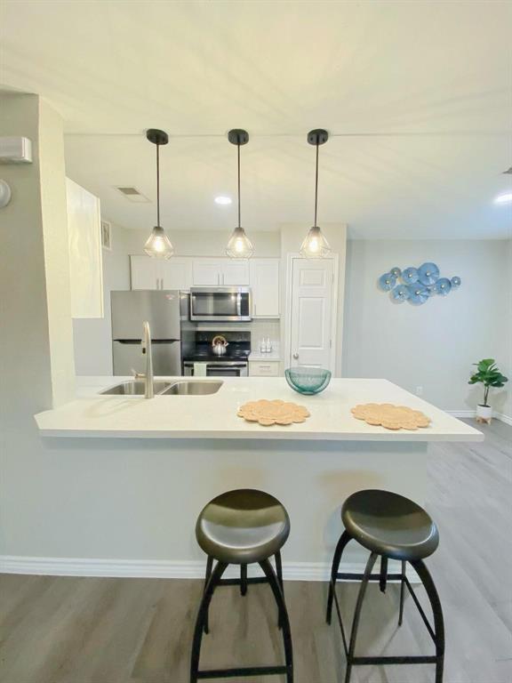 a kitchen with stainless steel appliances a white table chairs and a refrigerator