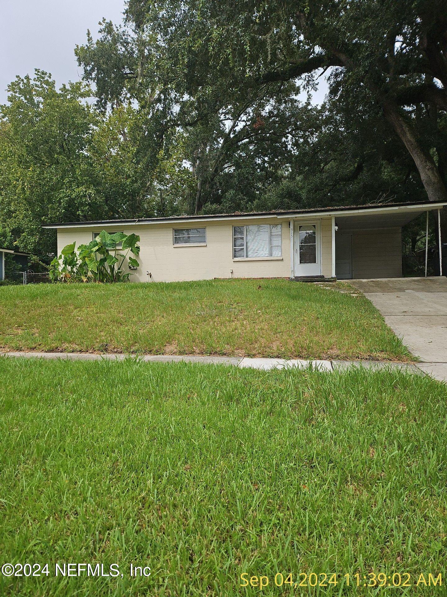 a backyard of a house with lots of green space and garden