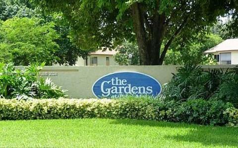 a sign of golf club on a wall under a tree