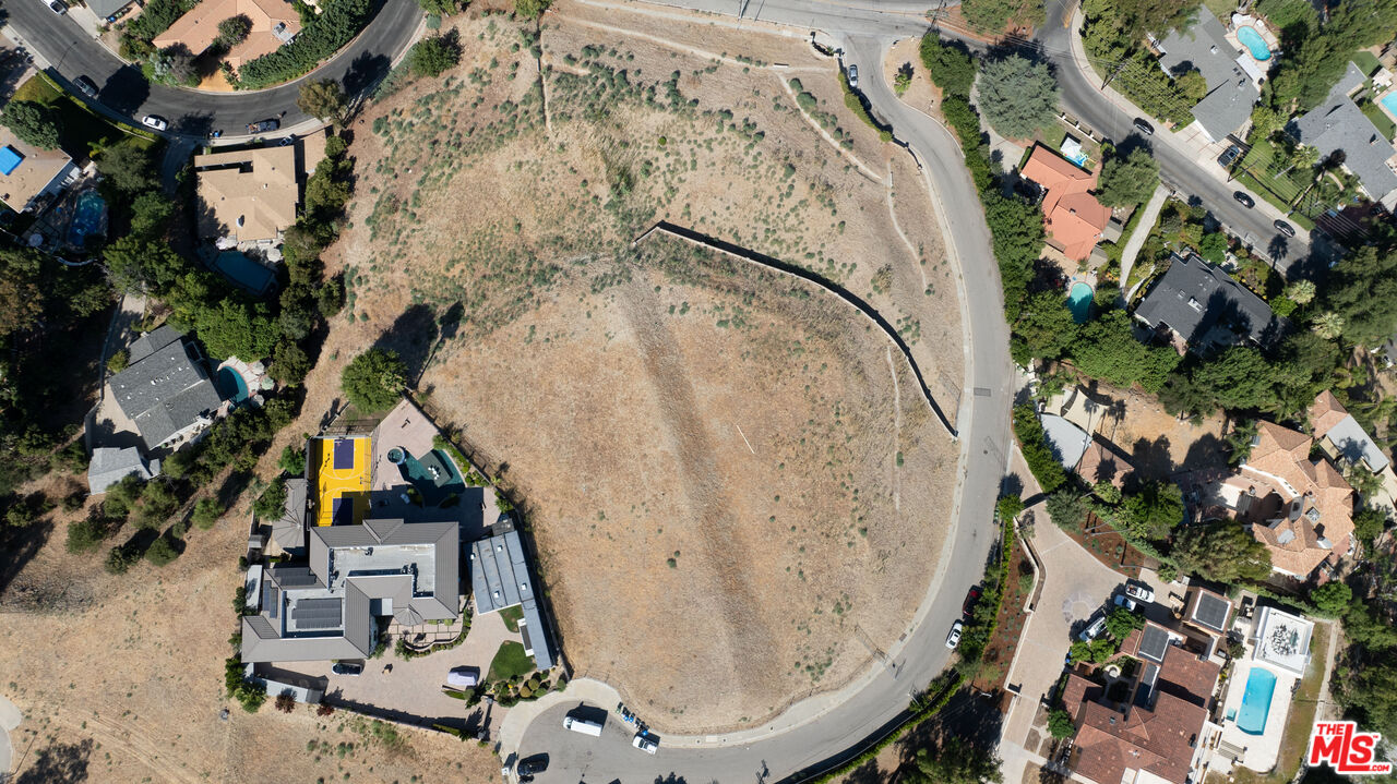 an aerial view of a house with a yard and wooden fence