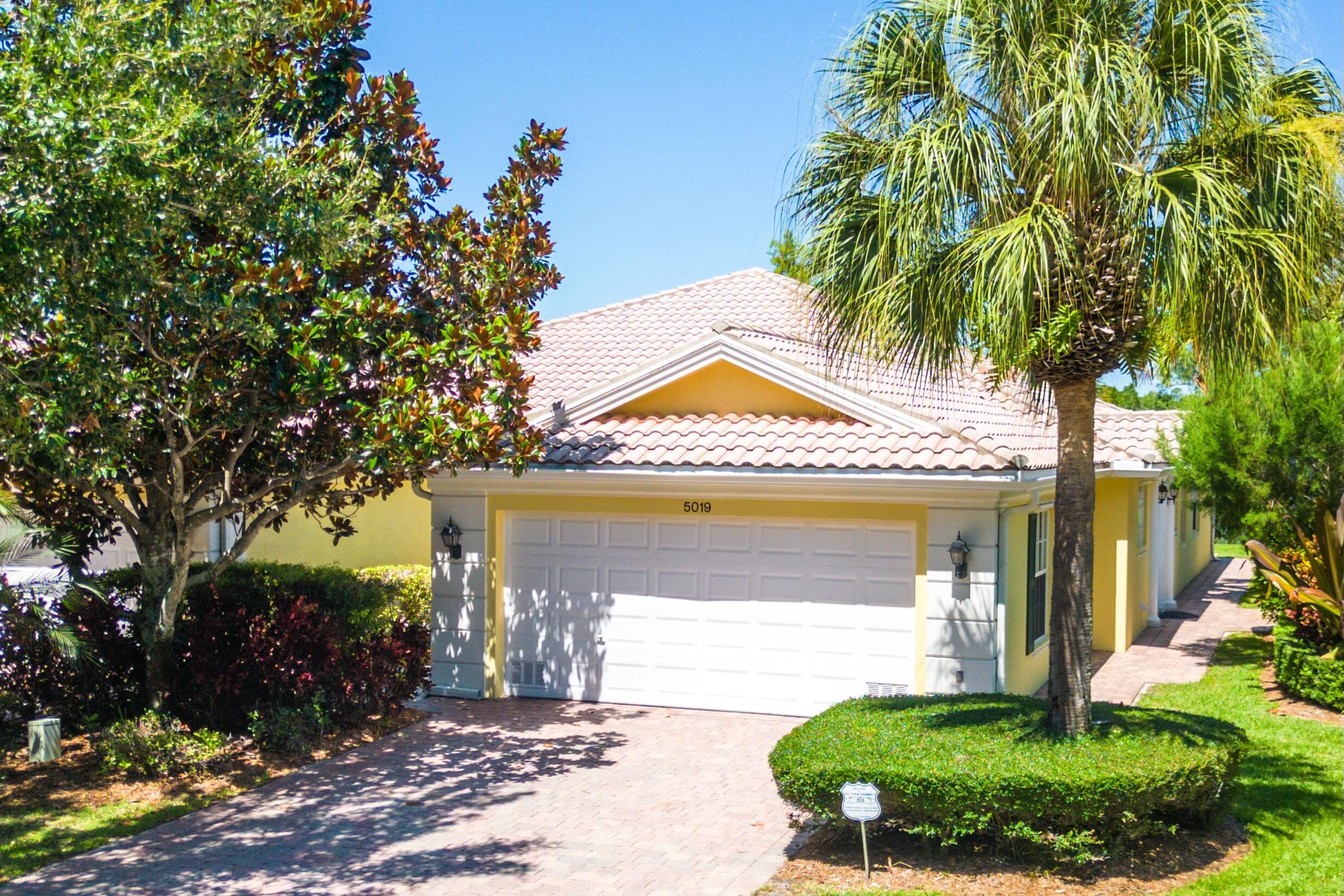 a view of a house with a yard and potted plants