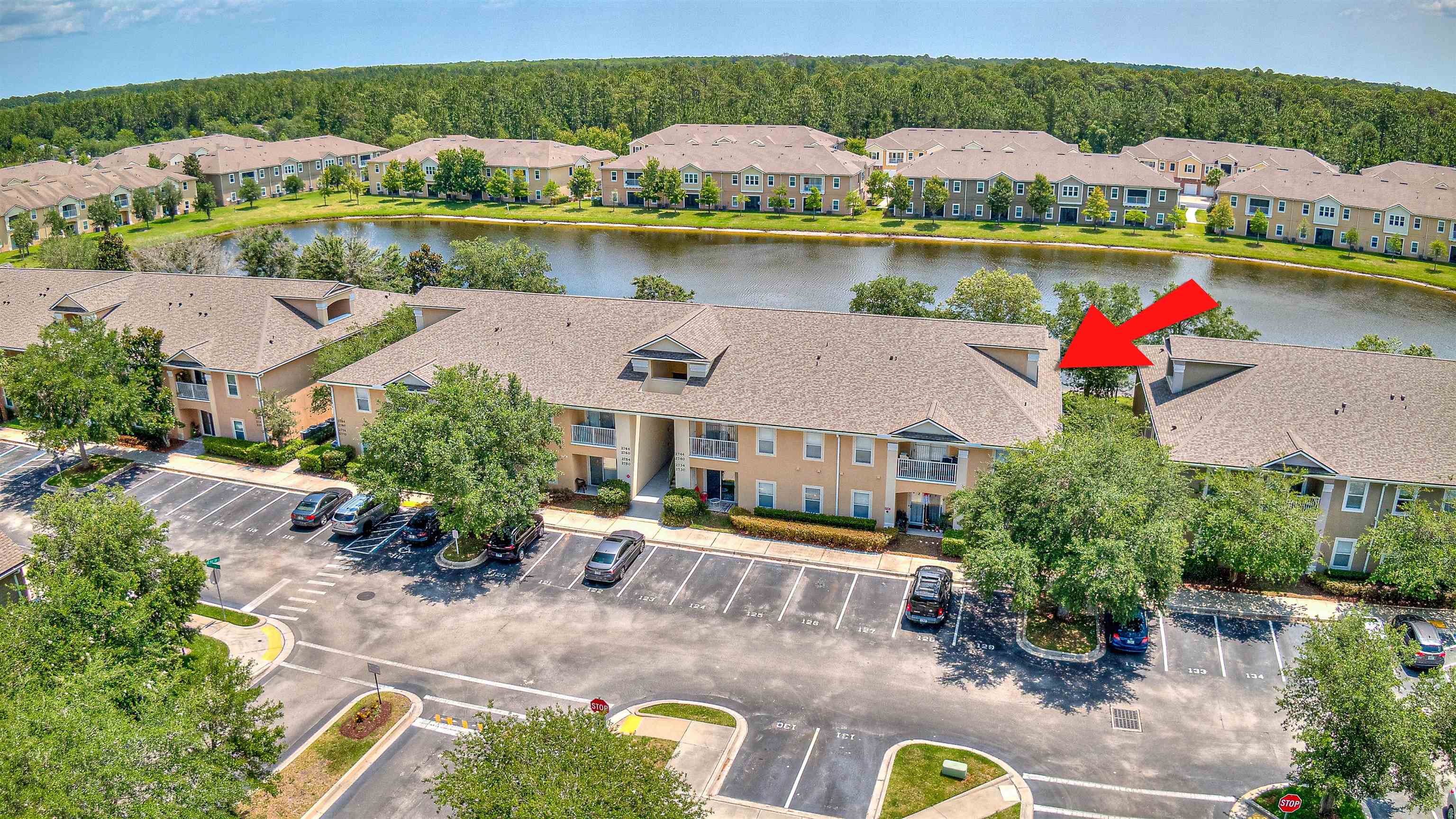 an aerial view of residential houses with outdoor space and lake view