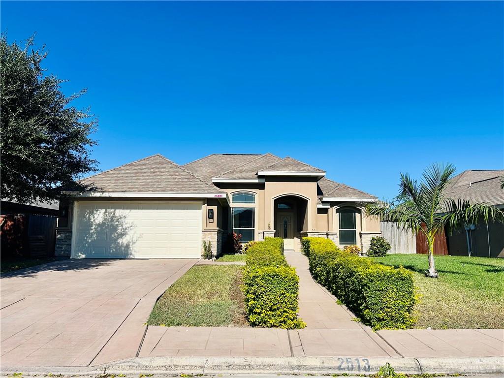 View of front of house with a garage and a front lawn