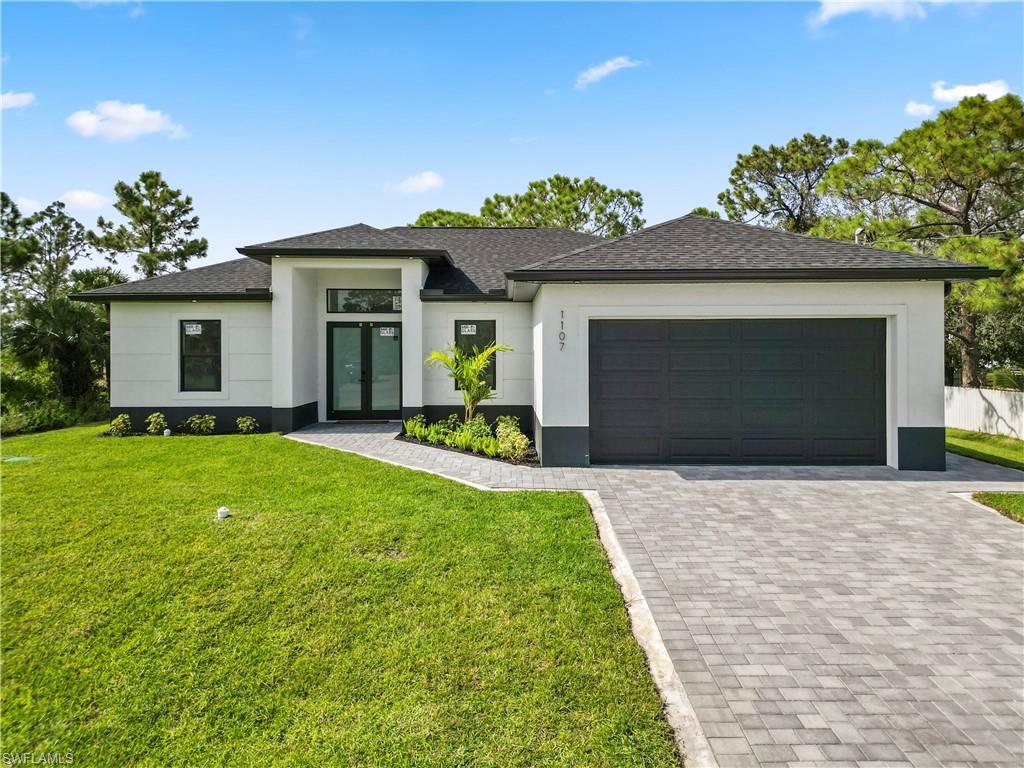 View of front of home with a front lawn and a garage