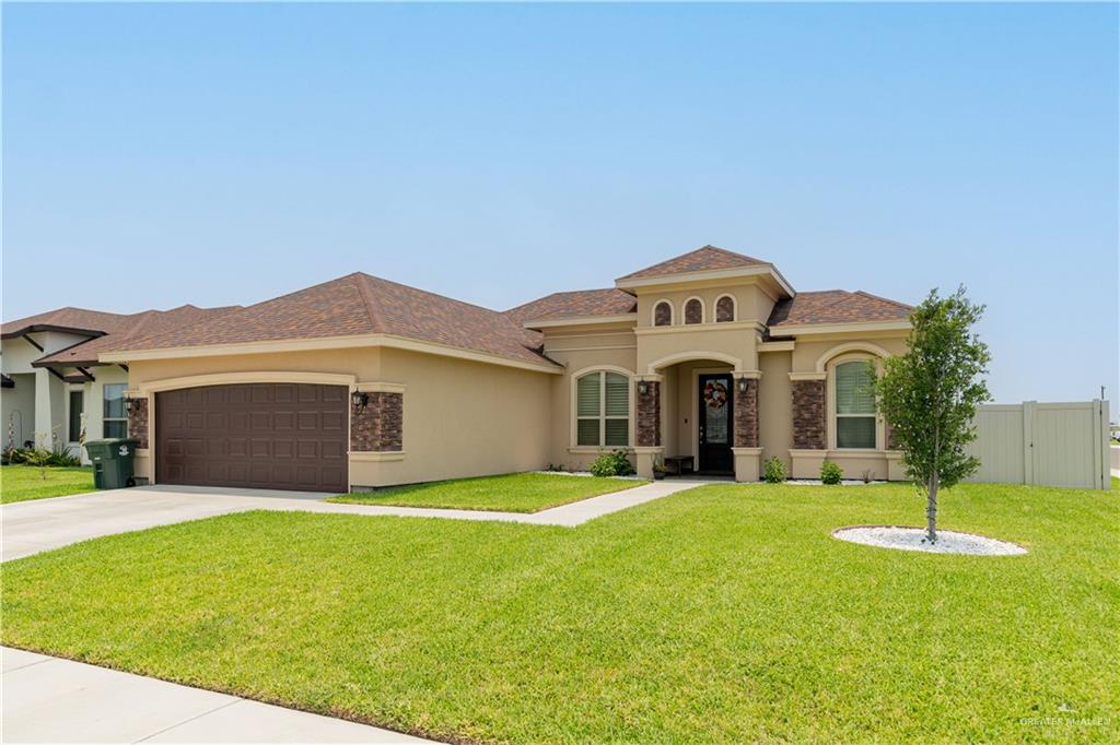 a front view of a house with a yard and garage