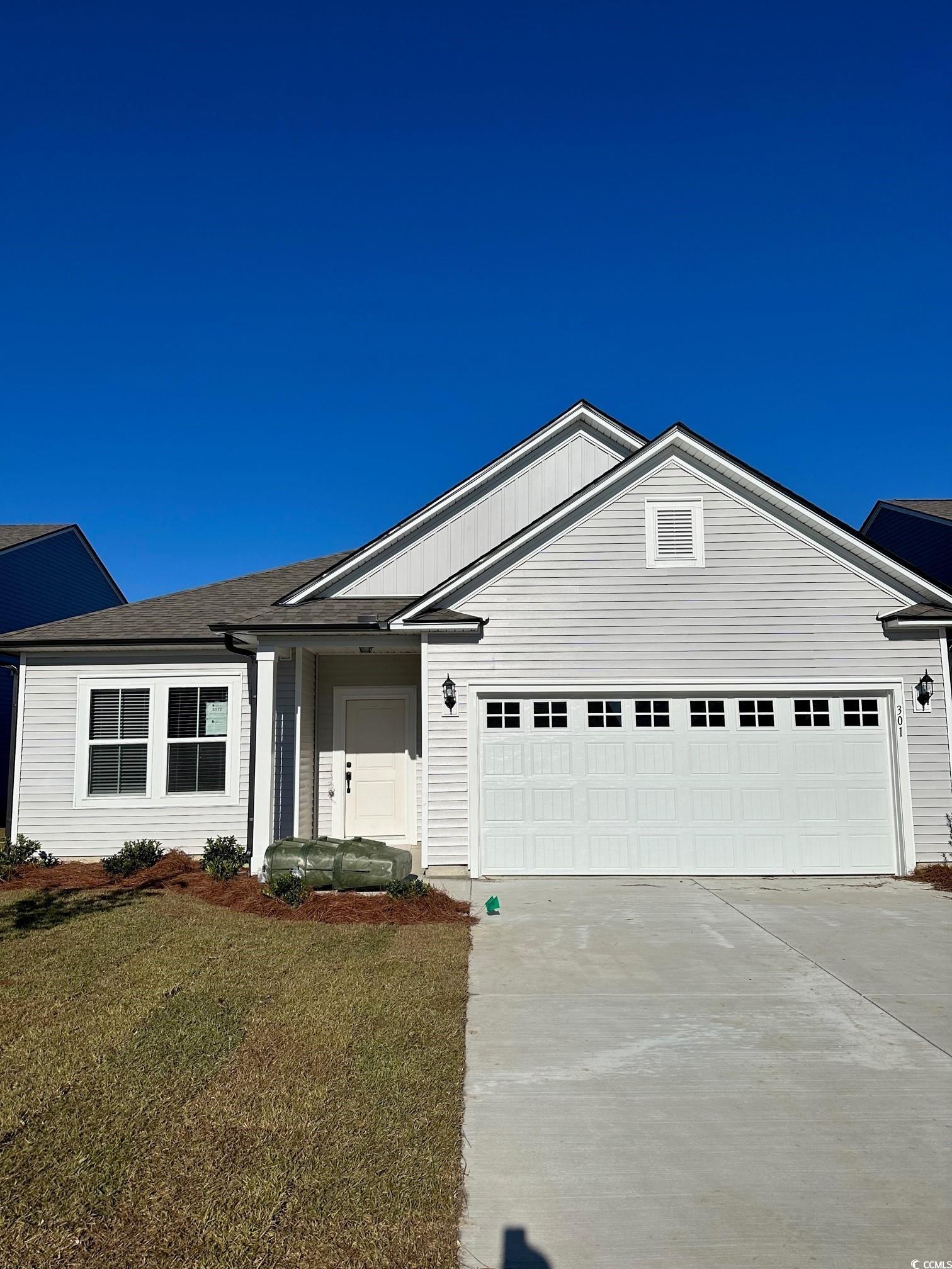 Single story home featuring a garage and a front y