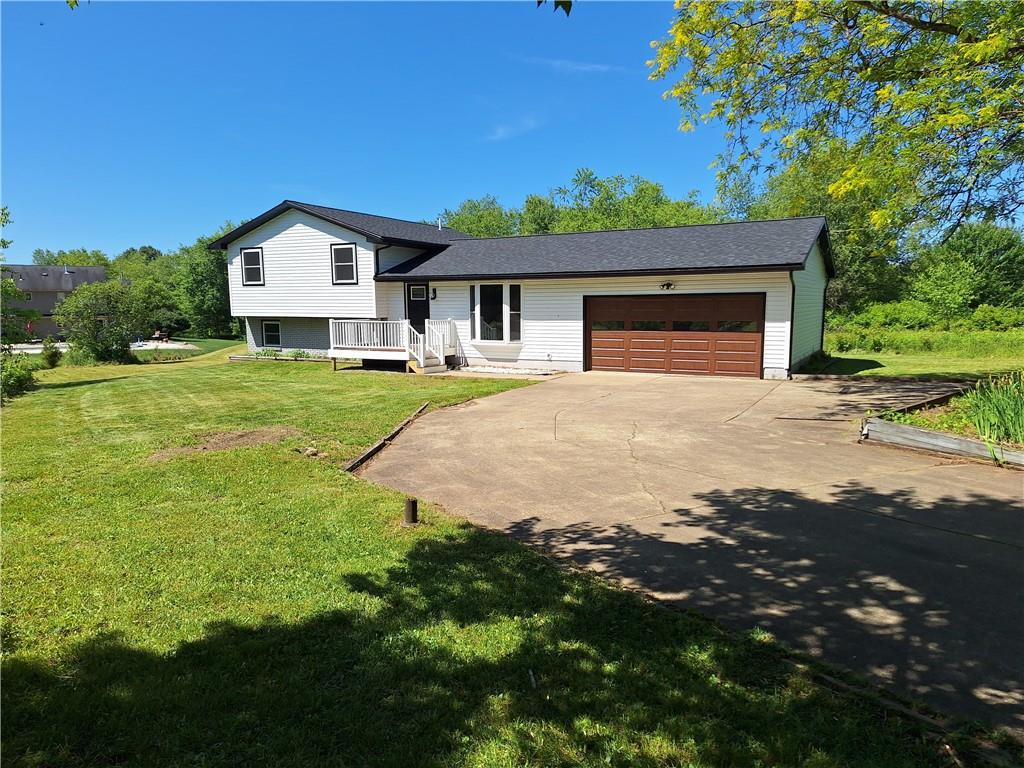 a front view of a house with yard and green space