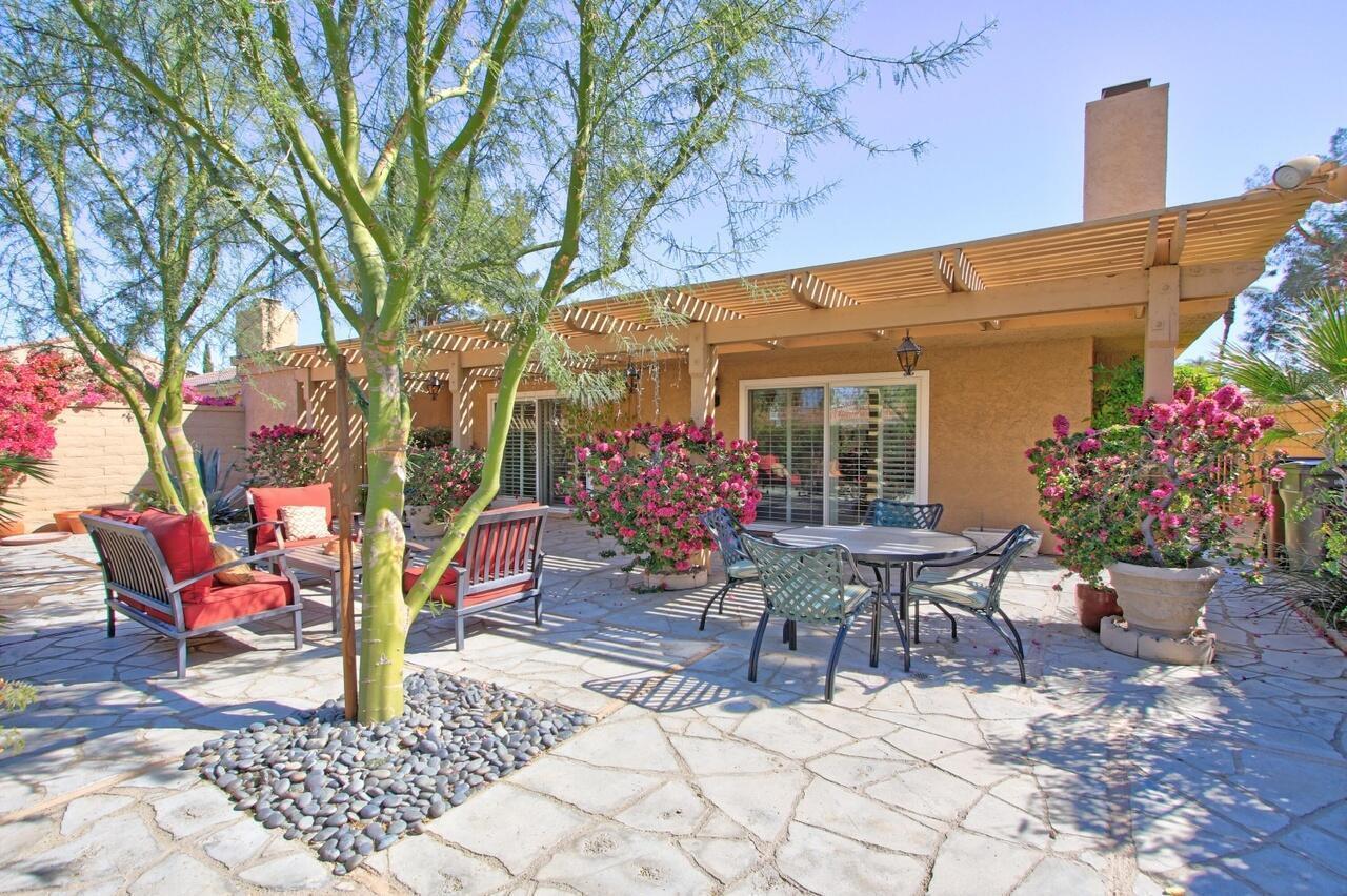 a view of a patio with table and chairs and potted plants