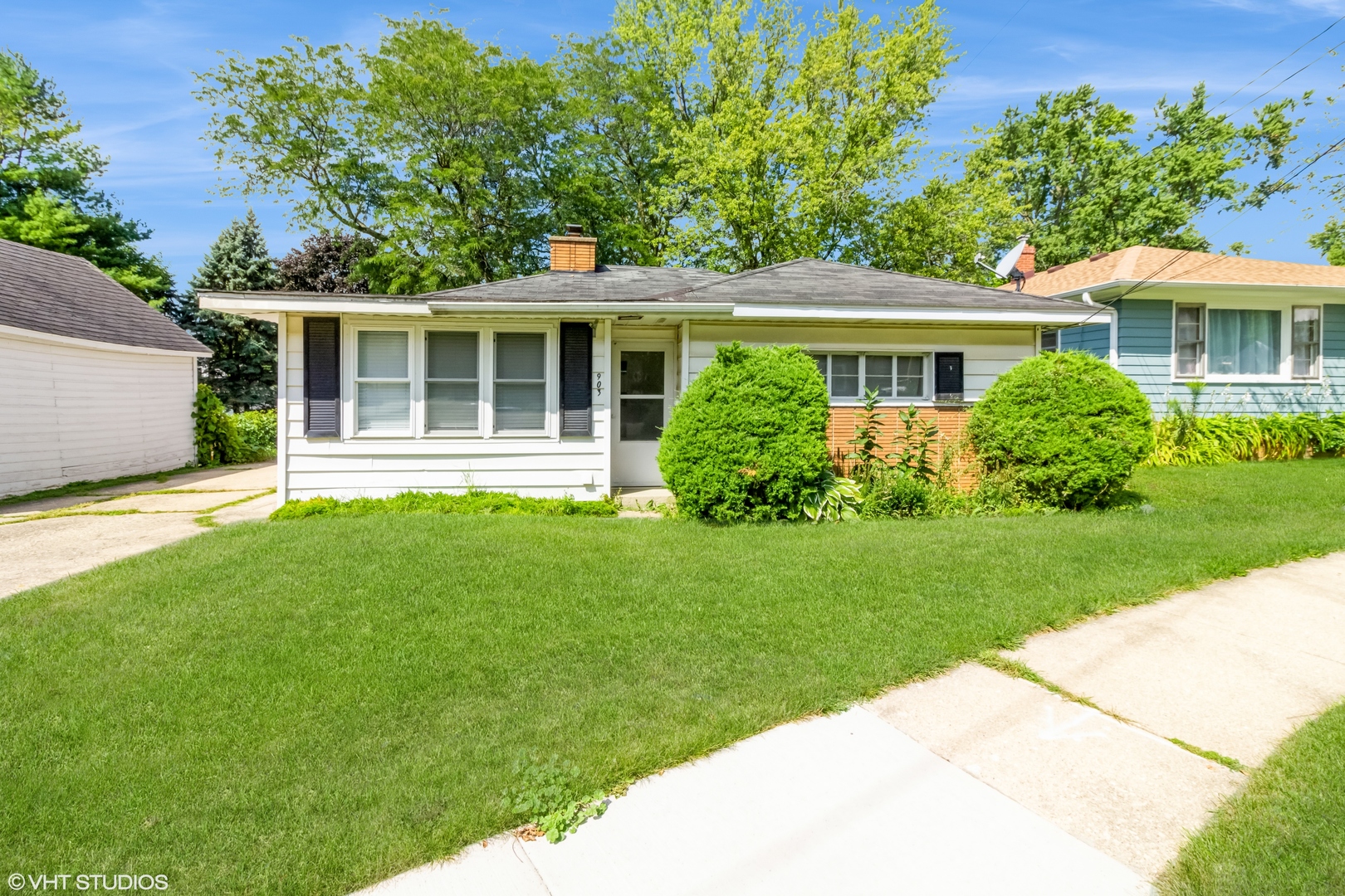 a view of a house with a yard and potted plants