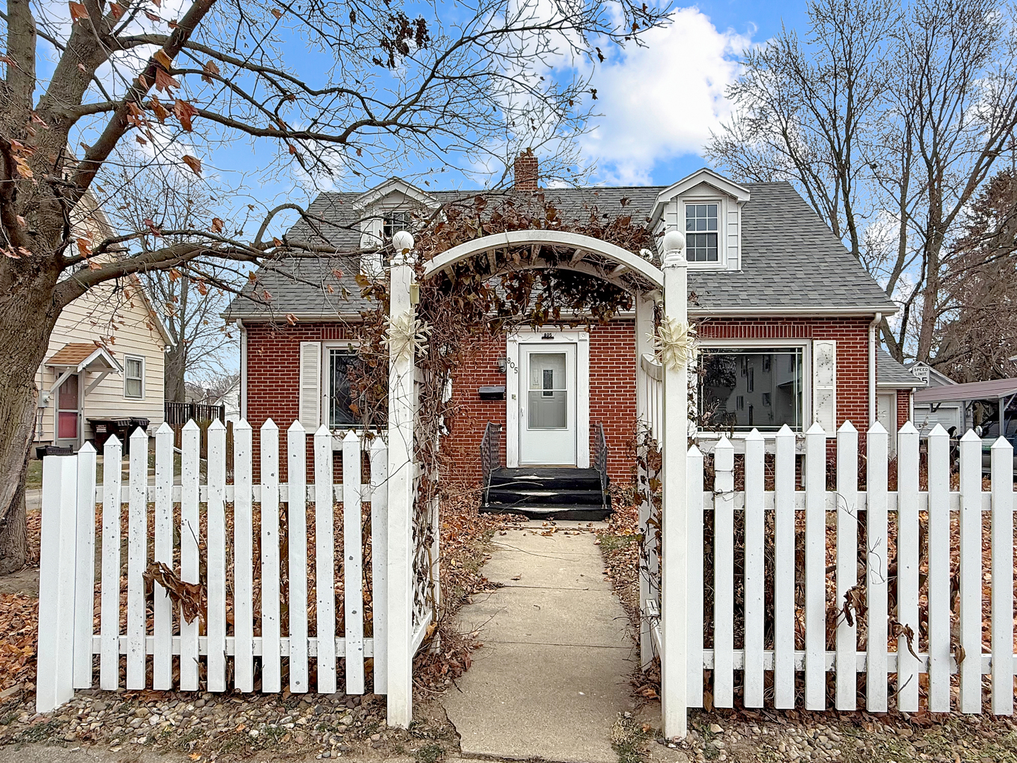 a front view of a house with a tree