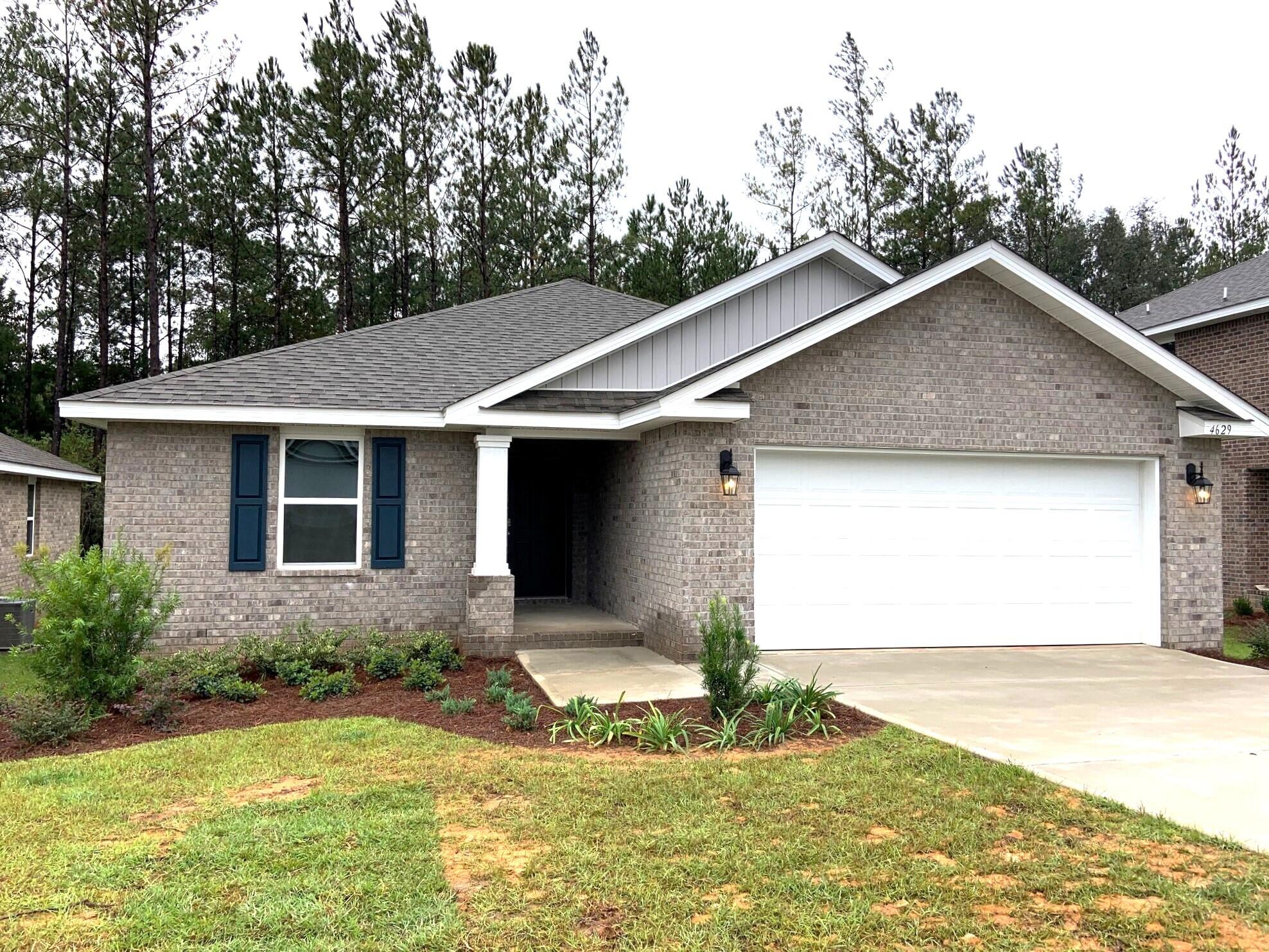 a front view of house with yard and trees in the background