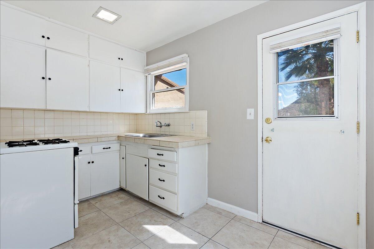 a kitchen with white cabinets and white appliances