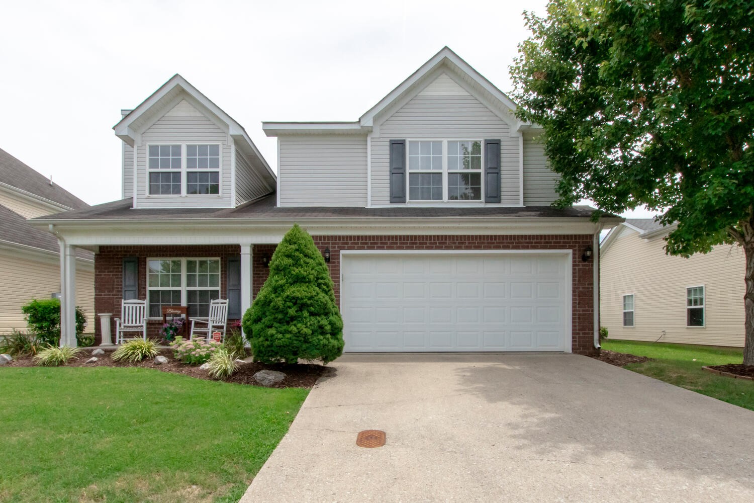 a front view of a house with a garden and garage