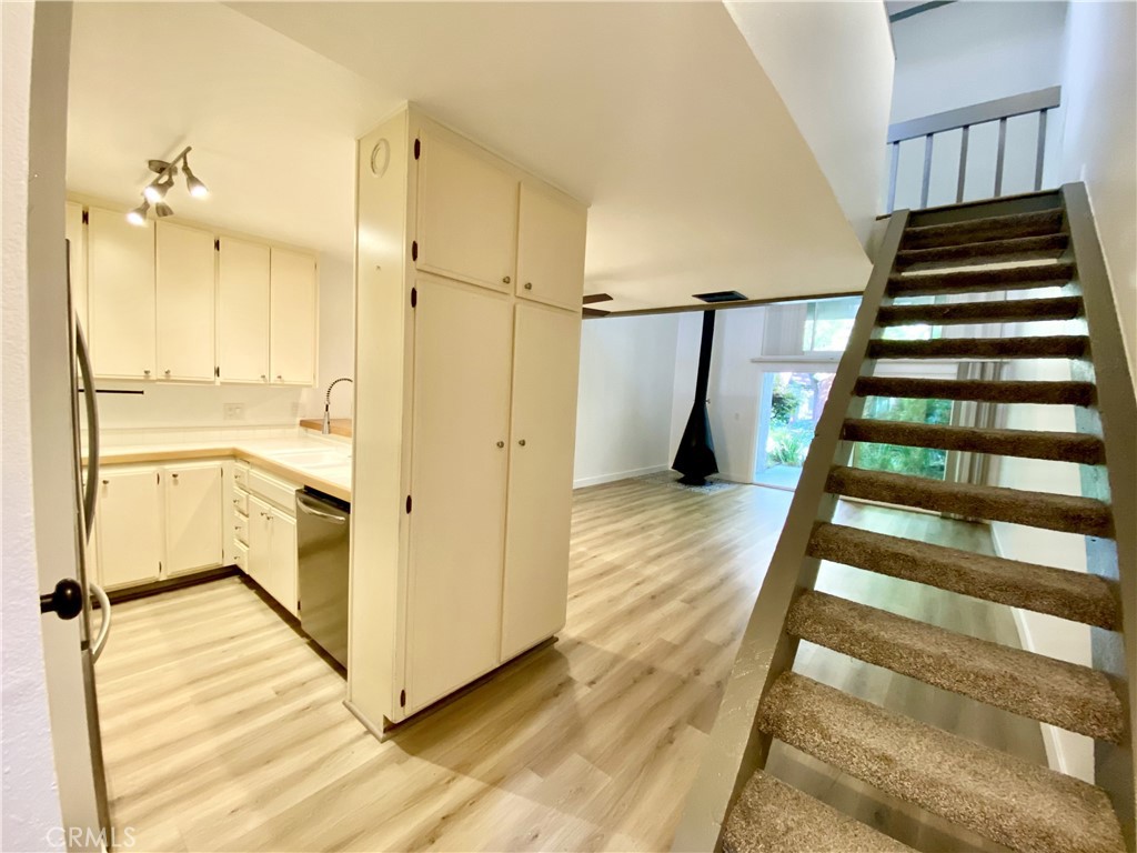 a view of a hallway with wooden floor and staircase