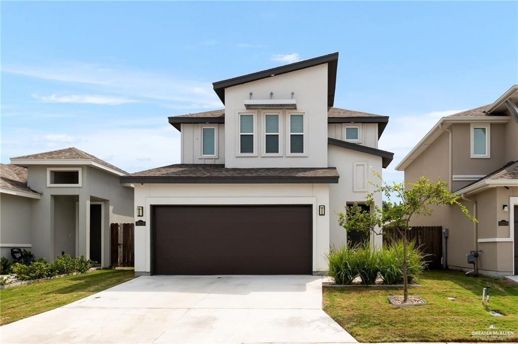 a front view of a house with a yard and garage