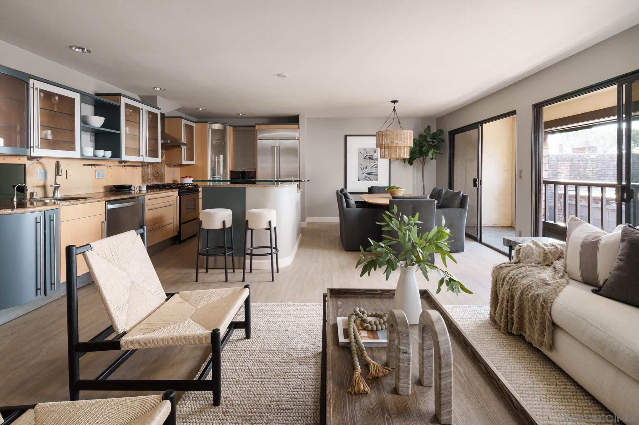 a living room with furniture kitchen view and large windows