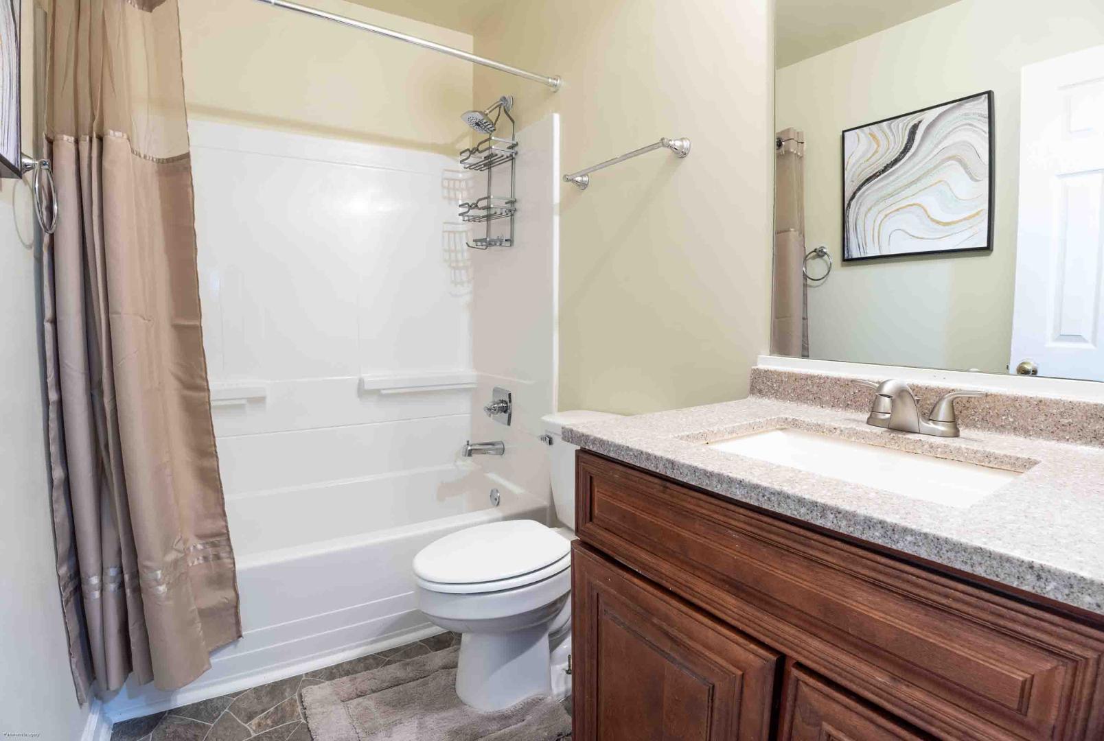 a bathroom with a granite countertop sink toilet and shower