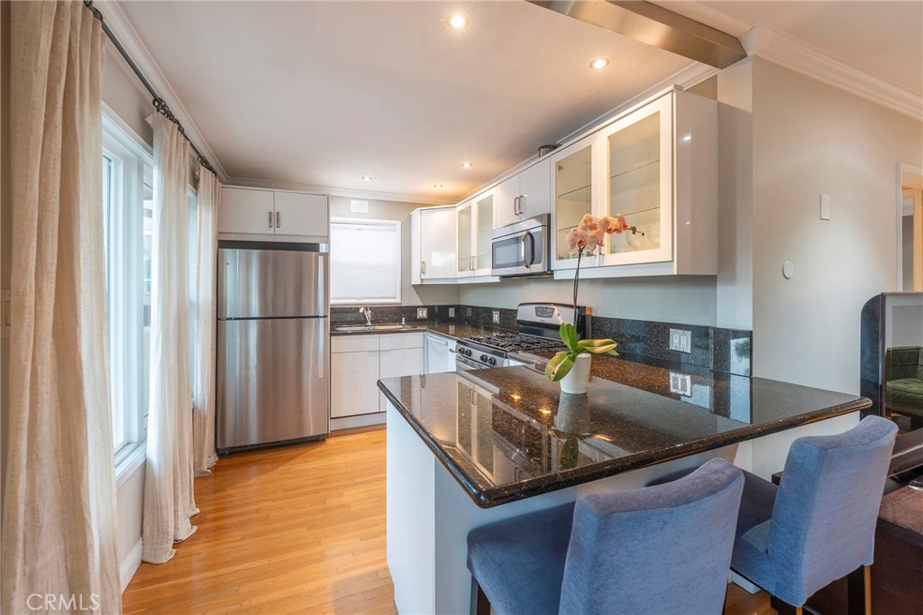 a kitchen with stainless steel appliances granite countertop a sink refrigerator and cabinets