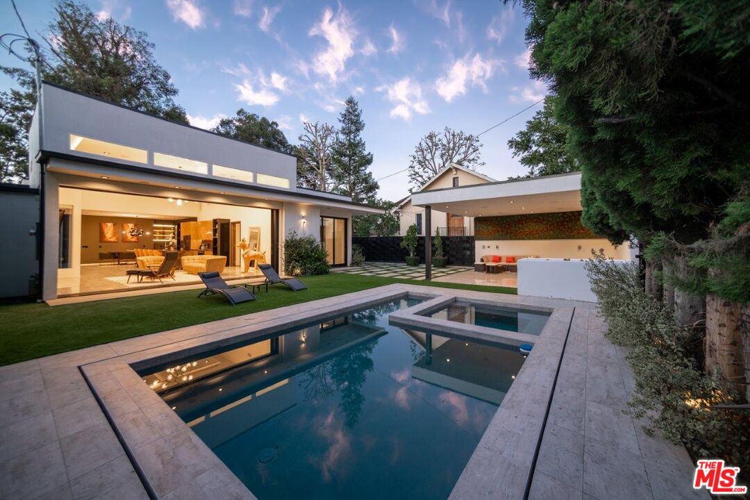 a view of house with swimming pool and outdoor seating