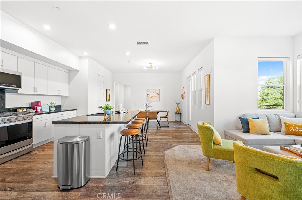 a kitchen with a table chairs stove and wooden floor