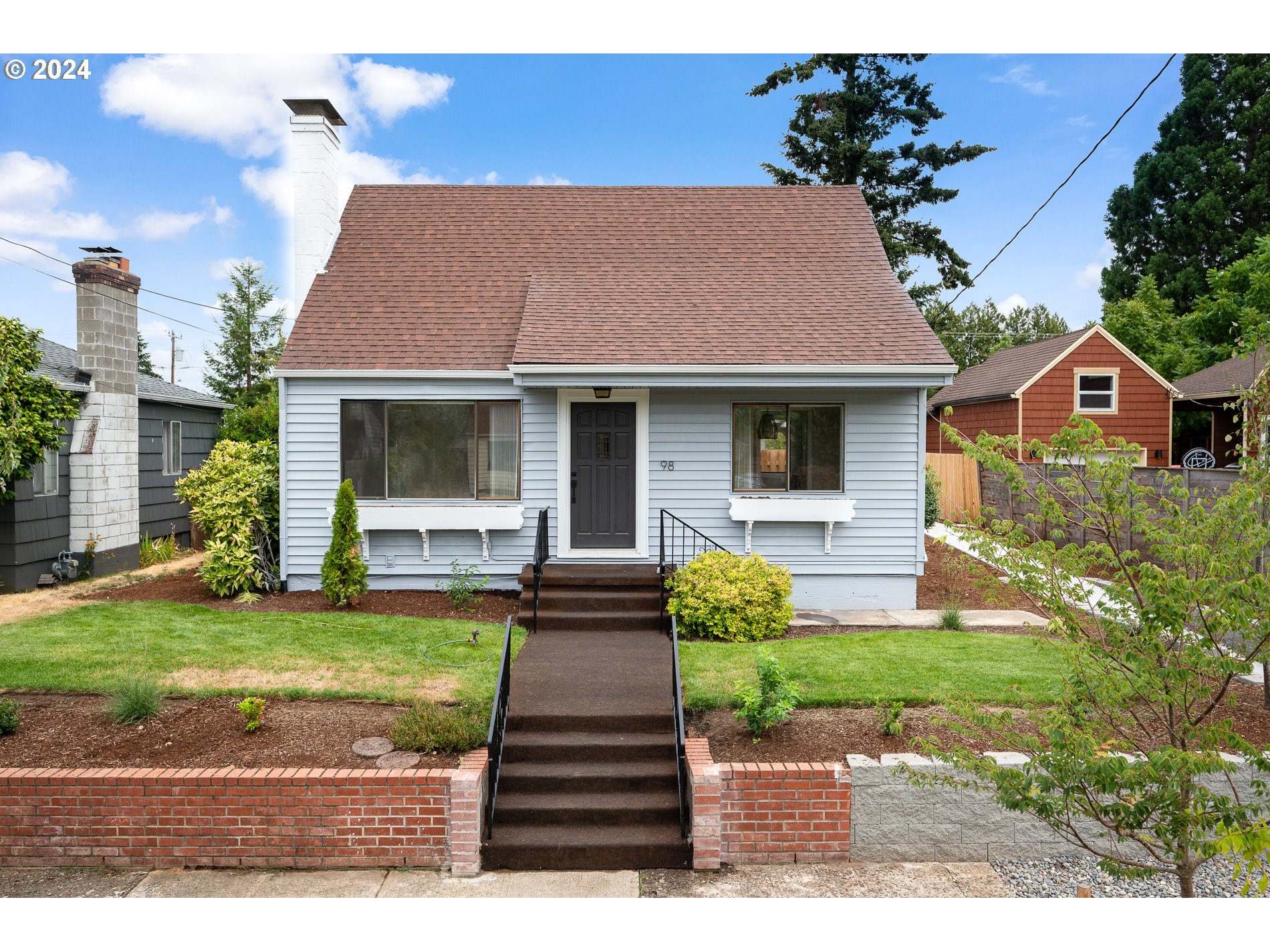 a front view of a house with a garden and yard