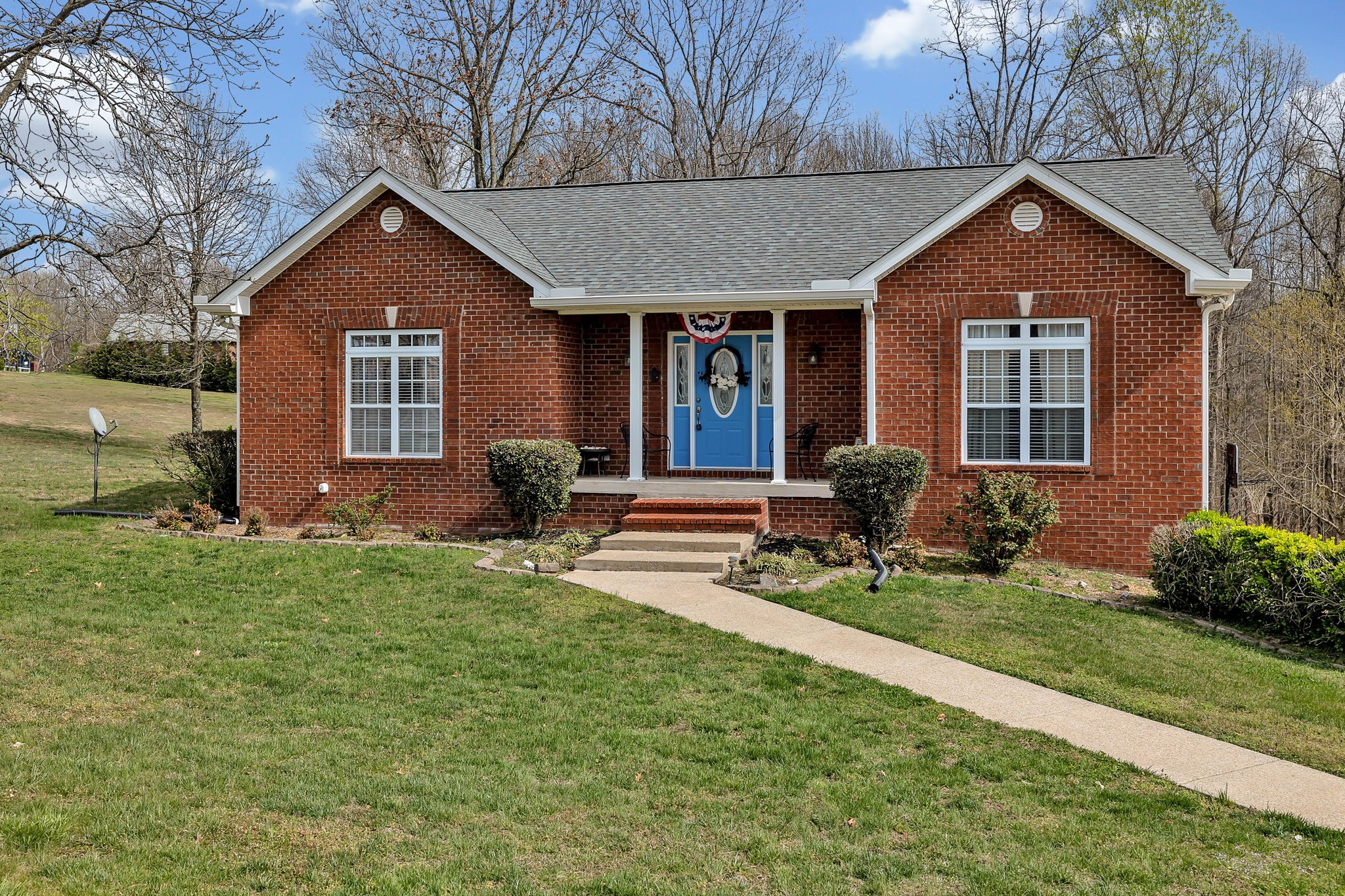 a front view of a house with a yard and seating space