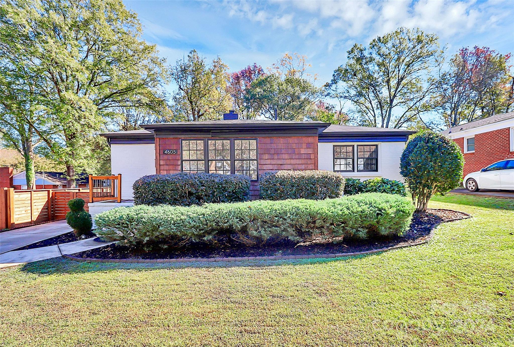 a front view of a house with a yard and potted plants