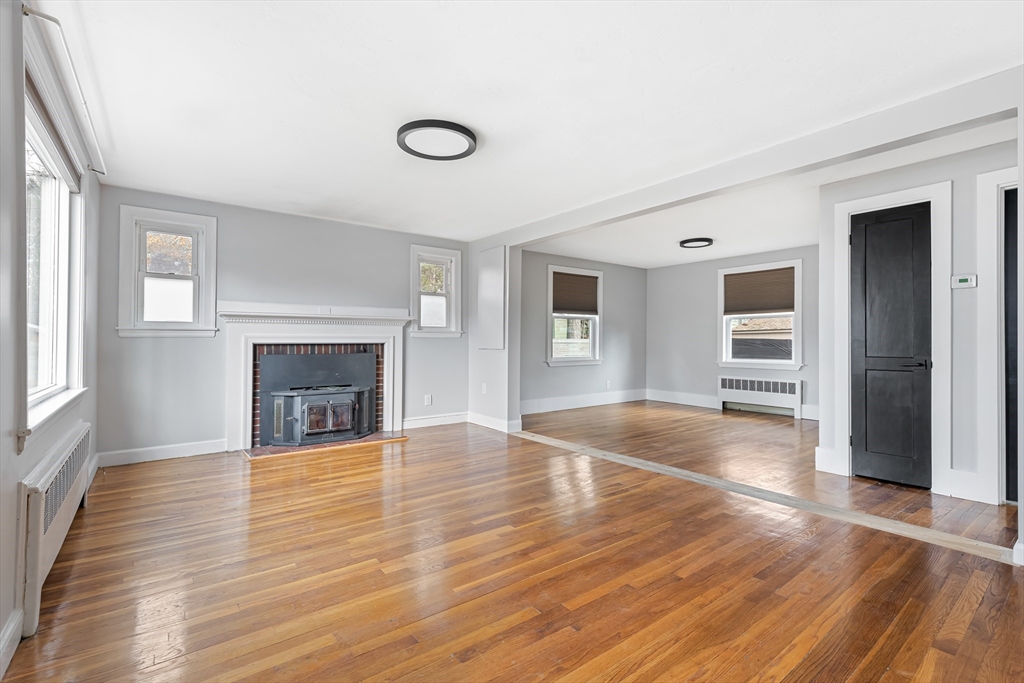 an empty room with wooden floor and fireplace