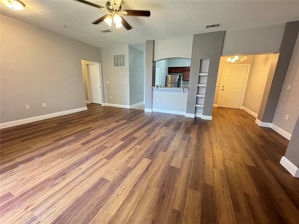 a view of empty room with wooden floor and fireplace